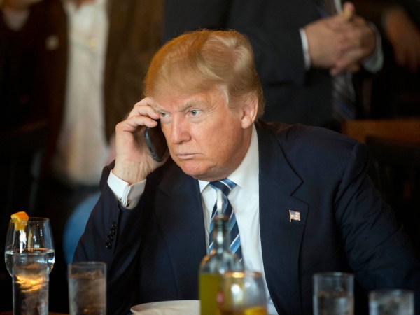FILE - In this Feb. 18, 2016 file photo, Republican presidential candidate Donald Trump listens to his mobile phone during a lunch stop in North Charleston, S.C. Trump’s approach to Twitter has been as unorthodox as his presidential campaign.The billionaire’s use of the social media service has been unpredictable and unfiltered, sometimes brilliant and occasionally typographically challenged. He has celebrated the support of scores of accounts that appear almost solely dedicated to him. (AP Photo/Matt Rourke, File)