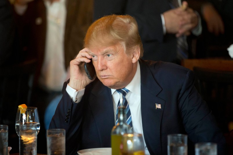 FILE - In this Feb. 18, 2016 file photo, Republican presidential candidate Donald Trump listens to his mobile phone during a lunch stop in North Charleston, S.C. Trump’s approach to Twitter has been as unorthodox as his presidential campaign.The billionaire’s use of the social media service has been unpredictable and unfiltered, sometimes brilliant and occasionally typographically challenged. He has celebrated the support of scores of accounts that appear almost solely dedicated to him. (AP Photo/Matt Rourke, File)