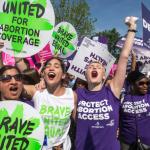 Abortion rights activists, from left, Ravina Daphtary of Philadelphia, Morgan Hopkins of Boston, and Alison Turkos of New York City, rejoice in front of the Supreme Court in Washington, Monday, June 27, 2016, as the justices struck down the strict Texas anti-abortion restriction law known as HB2. Other cases are to follow on guns, and public corruption. (AP Photo/J. Scott Applewhite)