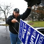 High School District 211 school board candidate Ed Yung, who supports the current agreement, unloads yard signs from the trunk of his car to post near polling places on Monday, April 3, 2017 in Hoffman Estates. (Stacey Wescott/Chicago Tribune)