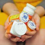 Heidi Wyandt, 27 holds a handful of her medication at the Altoona Center for Clinical Research where she receives experimental non-opioid pain medication for chronic back pain related to a work related injury she received in 2014 on Wednesday, March 29, 2017 in Altoona, PA. (AP Photo/Chris Post)