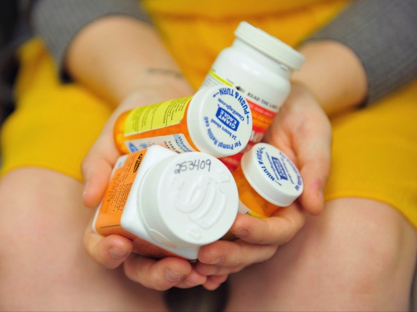 Heidi Wyandt, 27 holds a handful of her medication at the Altoona Center for Clinical Research where she receives experimental non-opioid pain medication for chronic back pain related to a work related injury she received in 2014 on Wednesday, March 29, 2017 in Altoona, PA. (AP Photo/Chris Post)