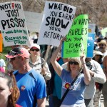 Protesters carry placards during a rally and march in downtown Denver Saturday, April 15, 2017. The rally in Denver was one of dozens in cities nationwide to call on President Donald Trump to release his tax returns, saying Americans deserve to know about his business ties and potential conflicts of interest. (AP Photo/David Zalubowski)