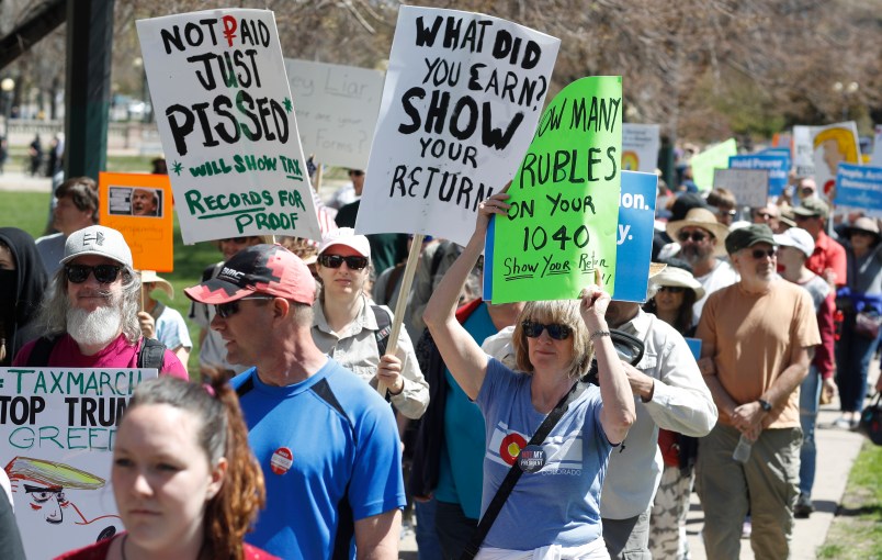 Protesters carry placards during a rally and march in downtown Denver Saturday, April 15, 2017. The rally in Denver was one of dozens in cities nationwide to call on President Donald Trump to release his tax returns, saying Americans deserve to know about his business ties and potential conflicts of interest. (AP Photo/David Zalubowski)