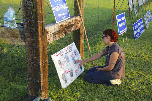 4/24/17Arkansas Democrat-Gazette/STEPHEN B. THORNTONNGina Grimm, daughter of executed inmate Jack Jones, touches a poster of those condemned to be executed in their taped off “protest corral” outside the Varner Unit shortly after 7 pm Monday evening April 24, 2017 near Varner, Ark.