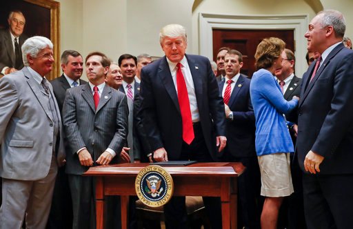 President Donald Trump, center, surrounded by Congressional and business leaders, gets up from his seat after signing an Executive Order in the Roosevelt Room of the White House in Washington, Friday, April 28, 2017. The Executive Order directs the Interior Department to begin review of restrictive drilling policies for the outer-continental shelf. (AP Photo/Pablo Martinez Monsivais)