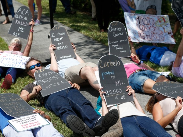 Demonstrators lie down during a health care protest outside U.S. Rep. Carlos Curbelo's offices, Thursday, May 4, 2017, in Miami. (AP Photo/Wilfredo Lee)