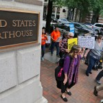 Protesters hold signs and march outside the US  4th Circuit Court of Appeals in Richmond, Va., Monday, May 8, 2017.  The court will examine a ruling that blocks the administration from temporarily barring new visas for citizens of Iran, Libya, Somalia, Sudan, Syria and Yemen. It's the first time an appeals court will hear arguments on the revised travel ban, which is likely destined for the U.S. Supreme Court.(AP Photo/Steve Helber)
