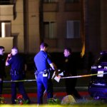 San Diego police officers stand in front of a La Jolla apartment after a shooting Sunday, April 30, 2017, in San Diego. San Diego Mayor Kevin Faulconer looks on at right. Police shot and killed a 49-year-old man suspected of shooting seven people Sunday at a birthday pool party in an apartment complex near the University of California, San Diego, authorities said. (AP Photo/Gregory Bull)