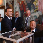 French President Emmanuel Macron, left, shakes hands wit a pooling station official after casting his ballot in the second round of the French parliamentary elections, in Le Touquet, northern France, Sunday, June 18, 2017. (Christophe Archambault/Pool Photo via AP)