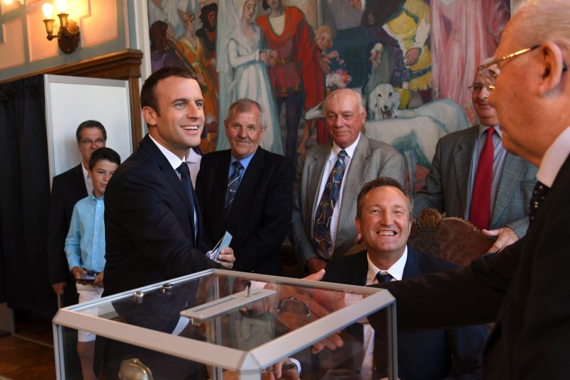 French President Emmanuel Macron, left, shakes hands wit a pooling station official after casting his ballot in the second round of the French parliamentary elections, in Le Touquet, northern France, Sunday, June 18, 2017. (Christophe Archambault/Pool Photo via AP)