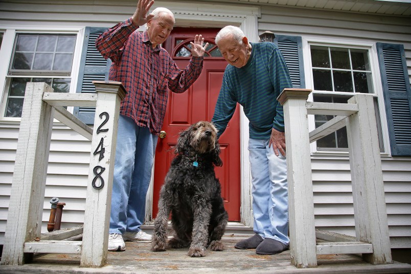 HOLD FOR EARLY RISER SUNDAY JULY 2, 2017 WITH STORY BY DAVID SHARP - In this Friday, June 30, 2017 photo 86-year-old Richard Prekins, right, Robert Maurais and their labradoodle "Scamp" outside their home in Ogunquit, Maine. Politicians have been chipping away at funding for heating aid to low-income Americans for a decade. Now President Donald Trump has proposed ending it altogether, eliciting an outcry from low-income residents who depend on the program to stay warm. (AP Photo/Stephan Savoia)