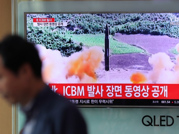 A man walks by a TV screen showing a local news program reporting about North Korea's missile firing at Seoul Train Station in Seoul, South Korea, Wednesday, July 5, 2017. North Korea's leader Kim Jong Un vowed his nation would "demonstrate its mettle to the U.S." and never put its weapons programs up for negotiations a day after test-launching its first intercontinental ballistic missile. The hard line suggests more tests are being prepared as the country tries to perfect a nuclear missile capable of striking anywhere in the United States. The letters read "North Korea, release an ICBM launching video." (AP Photo/Lee Jin-man)