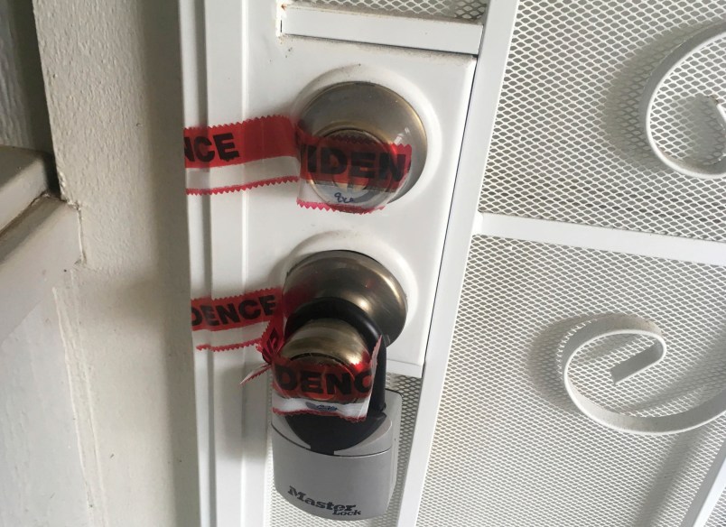 Red evidence tape covers part of the door leading to the condo where Ikaika Kang lives in Waipahu, Hawaii. The 34-year-old Army sergeant stationed in Hawaii is being held on terrorism charges after the FBI claims he tried to get secret military documents to the Islamic State. (AP Photo/Jennifer Sinco Kelleher)