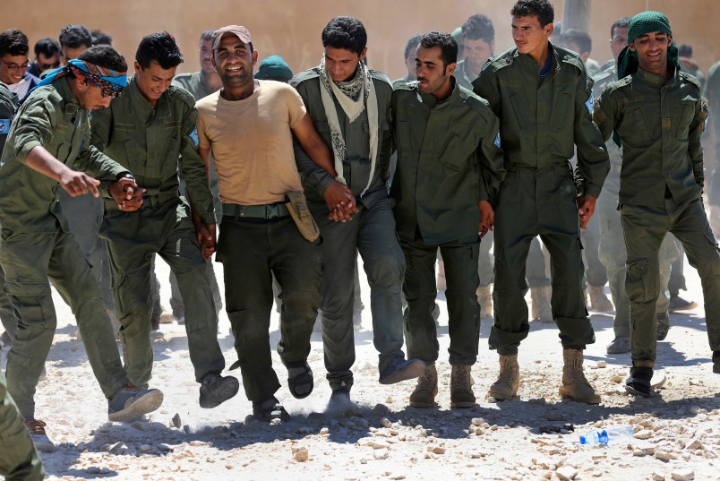 Syrian Internal Security Forces dance during their graduation ceremony, at Ain Issa desert base, in Raqqa province, northeast Syria, Thursday, July 20, 2017. Some 250 residents of Syria's Raqqa province are the latest batch to graduate from a brief U.S-training course that is preparing an internal security force to hold and secure areas as they are captured from Islamic State militants.(AP Photo/Hussein Malla)