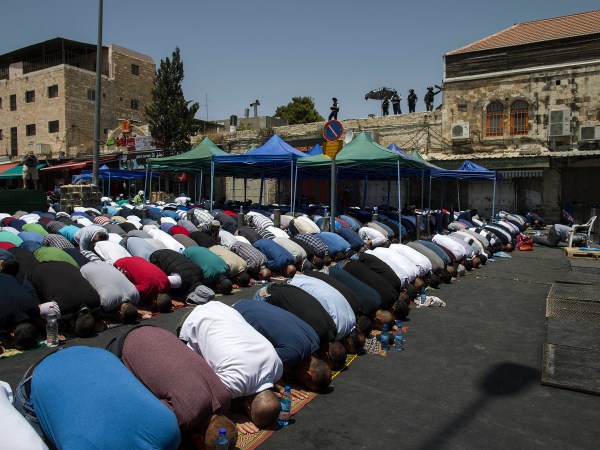 Palestinians pray outside the Damascus Gate in Jerusalem's Old City Friday, July 28, 2017. Muslim prayers at a major Jerusalem shrine ended peacefully Israeli police said Friday but violence continued in the West Bank where a Palestinian was killed attacking soldiers as forces were on high alert following two weeks of violence over the sacred site, holy to both Muslims and Jews. (AP Photo/Tsafrir Abayov)