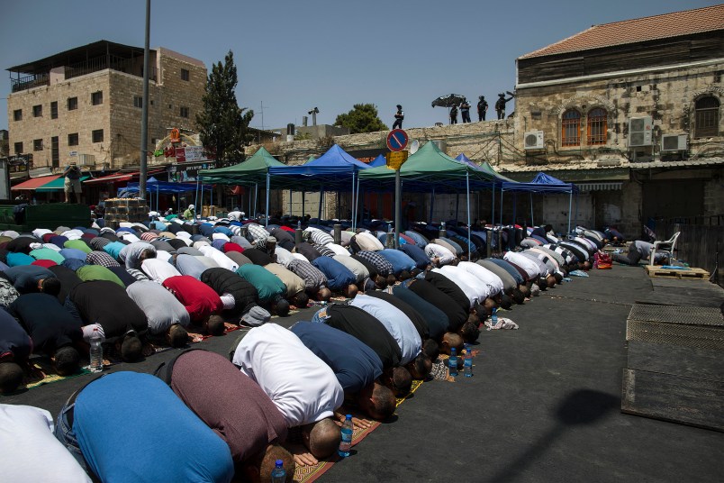 Palestinians pray outside the Damascus Gate in Jerusalem's Old City Friday, July 28, 2017. Muslim prayers at a major Jerusalem shrine ended peacefully Israeli police said Friday but violence continued in the West Bank where a Palestinian was killed attacking soldiers as forces were on high alert following two weeks of violence over the sacred site, holy to both Muslims and Jews. (AP Photo/Tsafrir Abayov)