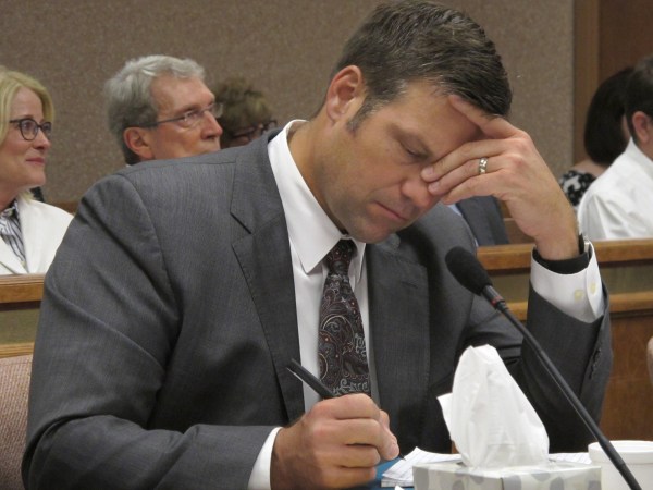 Kansas Secretary of State Kris Kobach listens and takes note as a judge declares in Shawnee County District Court that the state must count potentially thousands of votes from people who registered without providing documentation of their U.S. citizenship, Friday, July 29, 2016, in Topeka, Kan. Kobach had directed local election officials to count only their votes in federal races, not state and local ones. (AP Photo/John Hanna)