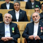 FILE-- In this file photo taken on Monday, Feb. 8, 2016, chief of Iran's Atomic Energy Organization Ali Akbar Salehi, right, sits next to Foreign Minister Mohammad Javad Zarif after being awarded medal of honor by President Hassan Rouhani during a ceremony in Tehran, Iran.  Iran's atomic chief warned Tuesday the Islamic Republic needs only five days to ramp up its uranium enrichment to 20 percent, a level at which the material could be used for a nuclear weapon. (AP Photo/Ebrahim Noroozi, File)