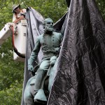 City workers drop a tarp over the statue of Confederate General Stonewall Jackson in Justice park in Chrlottesville, Va., Wednesday, Aug. 23, 2017.  The move intended to symbolize the city's mourning for a woman killed while protesting a white nationalist rally earlier this month. (AP Photo/Steve Helber)