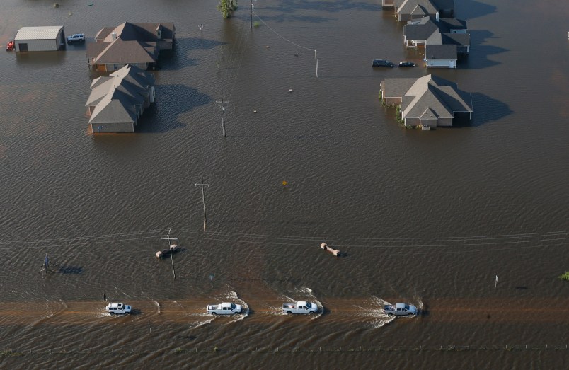 Trucks drive on a flooded rowdy past flooded houses in the aftermath of Tropical Storm Harvey in Orange, Texas, Thursday, Aug. 31, 2017. (AP Photo/Gerald Herbert)