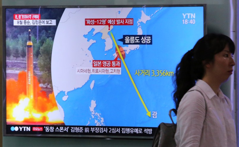 A woman passes by a TV screen showing a local news program reporting on North Korea threatens to strike Guam with ballistic missiles at the Seoul Train Station in Seoul, South Korea, Thursday, Aug. 10, 2017.  North Korea has announced a detailed plan to launch a salvo of ballistic missiles toward the U.S. Pacific territory of Guam, a major military hub and home to U.S. bombers. If carried out, it would be the North’s most provocative missile launch to date. The signs at left top read " North Korea announced a plan to launch a salvo of ballistic missiles toward the Guam. (AP Photo/Ahn Young-Joon)