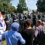 Alt Right demonstrators hold their ground against Virginia State Police as police fire tear gas rounds in Lee Park in Charlottesville, Va., Saturday, Aug. 12, 2017.  (AP Photo/Steve Helber)