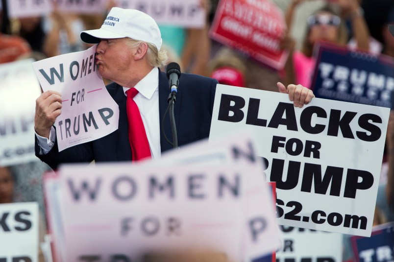 Republican presidential candidate Donald Trump kisses a "Women for Trump" sign during a campaign rally, Wednesday, Oct. 12, 2016, in Lakeland, Fla. (AP Photo/ Evan Vucci)