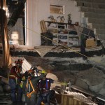 Rescue workers evacuate by rain the collapsed office building at the corner of Alvaro Obregon and Yucatan streets in Mexico City, early Monday Sept 25, 2017. Search teams are still digging in dangerous piles of rubble hoping against the odds to find survivors at collapsed buildings. (AP Photo/Miguel Tovar)