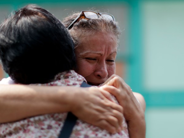 Maria Susana Fernandez Lopez embraces a neighbor outside a school working as a temporary home where she is living after loosing her home during the earthquake in Mexico City, Mexico, Tuesday, Sept. 26, 2017. (AP Photo/Natacha Pisarenko)