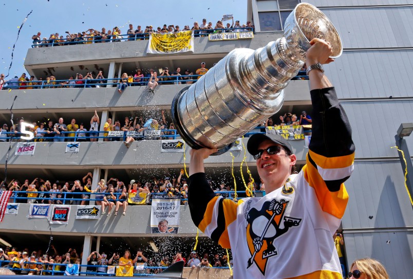 Pittsburgh Penguins' Sidney Crosby hoists the Stanley Cup while riding in the Stanley Cup victory parade in Pittsburgh, Wednesday, June 14, 2017. (AP Photo/Gene J. Puskar)