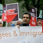 FILE--In this May 15, 2017, file photo, protesters hold signs during a demonstration against President Donald Trump's revised travel ban, Monday, May 15, 2017, outside a federal courthouse in Seattle. A three-judge panel of the 9th U.S. Circuit Court of Appeals on Monday upheld a decision to block the revised travel ban, which would suspend the nation's refugee program and temporarily bar new visas for citizens of Iran, Libya, Somalia, Sudan, Syria and Yemen. (AP Photo/Ted S. Warren, file)