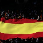 People hold a Spanish flag as they march during a protest the regional Catalan government's push to break away from the rest of Spain in Barcelona, Spain, Sunday, March 19, 2017. Several protesters carried Spanish flags and signs saying "Stop the Coup"  a reference to the regional government's plan to hold a referendum on independence, which Spain says is unconstitutional. (AP Photo/Manu Fernandez)