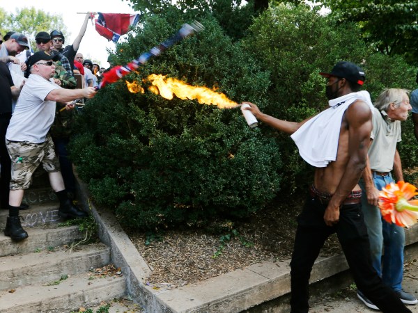A counter demonstrator uses a lighted spray can against a white nationalist demonstrator at the entrance to Lee Park in Charlottesville, Va., Saturday, Aug. 12, 2017.   Gov. Terry McAuliffe declared a state of emergency and police dressed in riot gear ordered people to disperse after chaotic violent clashes between white nationalists and counter protestors. (AP Photo/Steve Helber)