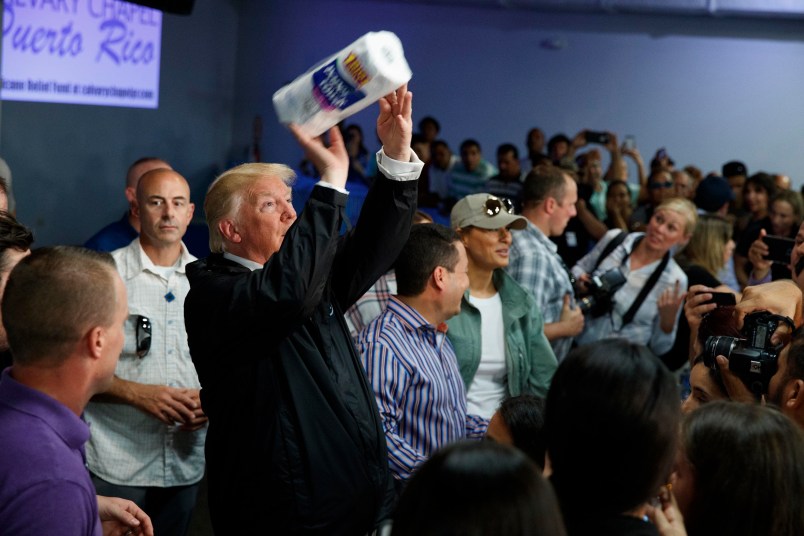 President Donald Trump tosses paper towels into a crowd as he hands out supplies at Calvary Chapel, Tuesday, Oct. 3, 2017, in Guaynabo, Puerto Rico. (AP Photo/Evan Vucci)