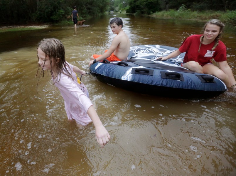 Crimson Peters, 7, left, Tracy Neilsen, 13, center, and Macee Nelson, 15, ride an inter tube in down a flooded street after Hurricane Nate, Sunday, Oct. 8, 2017, in Coden, Ala. (AP Photo/Brynn Anderson)