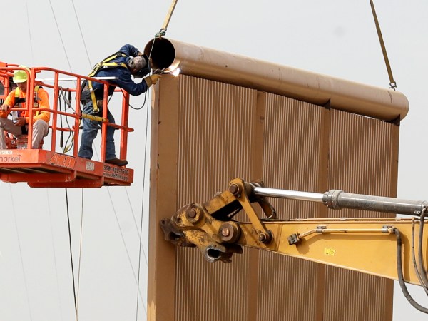 Crews work on a border wall prototype near the border with Tijuana, Mexico, Thursday, Oct. 19, 2017, in San Diego. Companies are nearing an Oct. 26 deadline to finish building eight prototypes of President Donald Trump’s proposed border wall with Mexico. The models, which cost the government up to about $500,000 each, should be able to take an hour of punishment from a sledgehammer, pickaxe, torch, chisel and battery-operated tools and be “aesthetically pleasing” from the U.S. side. (AP Photo/Gregory Bull)