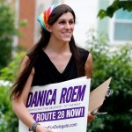 Democratic nominee for the House of Delegates 13th district seat, Danica Roem, brings campaign signs as she greets voters while canvasing a neighborhood Wednesday, June 21, 2017, in Manassas, Va. Roem is running against Del. Bob Marshall in the 13th House of Delegates District. (AP Photo/Steve Helber)
