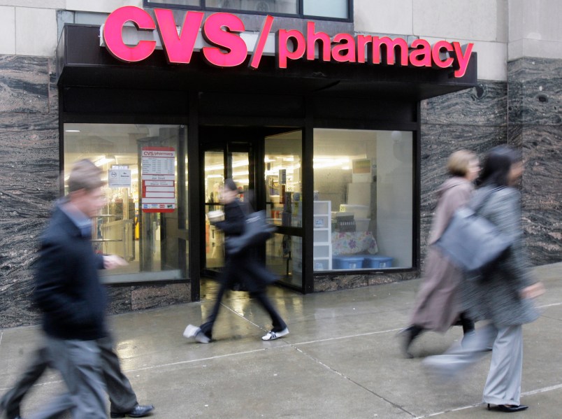 People walk past a CVS pharmacy in downtown Chicago Tuesday, March 18, 2008. On Tuesday, a settlement was announced in Chicago that Rhode Island-based CVS Caremark Corporation has agreed to pay almost $37 million to the federal government, 23 states and the District of Columbia to settle claims it billed Medicaid programs for a more expensive formulation of an antacid. The investigation began more than five years ago after a suburban Chicago pharmacist alerted authorities. (AP Photo/M. Spencer Green)