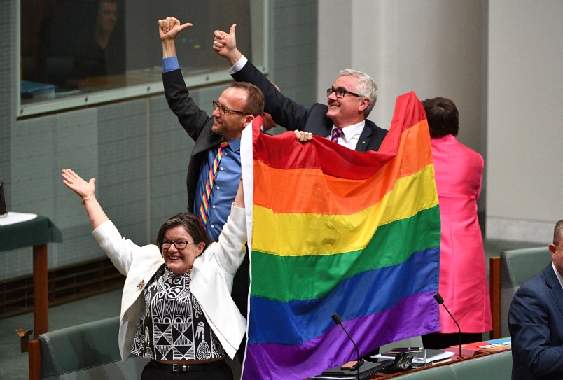 Members of parliament Cathy McGowan, Adam Brandt and Andrew Wilkie celebrate the passing of the Marriage Amendment Bill in the House of Representatives at Parliament House in Canberra, Thursday, Dec. 7, 2017. Gay marriage was endorsed by 62 percent of Australian voters who responded to a government-commissioned postal ballot by last month. (Mick Tsikas/AAP Image via AP)