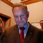 U.S. Senate candidate Roy Moore, center, looks at election returns with staff during an election-night watch party at the RSA activity center, Tuesday, Dec. 12, 2017, in Montgomery, Ala. (AP Photo/Brynn Anderson)