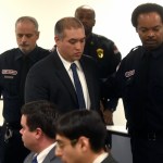 FILE - in this Dec. 21, 2017 file photo, former Michigan State Trooper Mark Bessner, center, arrives at his arraignment in 36th District Court in Detroit. Bessner is charged with murder in the death of Damon Grimes after he fired a Taser at the teenager who crashed an all-terrain vehicle and died. Bessner is charged with murder in the death of Grimes, but it wasn’t his only incident involving a Taser. State police wanted to suspend Bessner for 10 days for firing his Taser twice at a handcuffed man who was running away in 2016. He was also questioned in a separate 2014 taser incident. (Max Ortiz/Detroit News via AP File)
