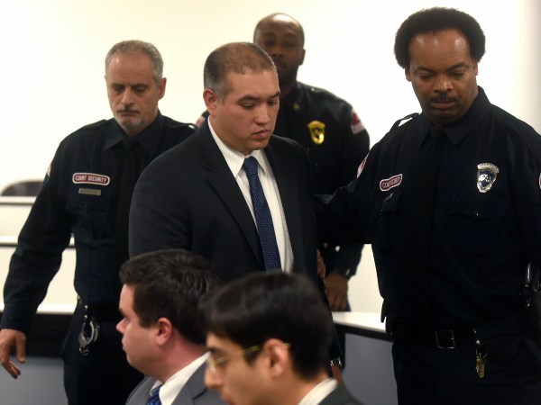 FILE - in this Dec. 21, 2017 file photo, former Michigan State Trooper Mark Bessner, center, arrives at his arraignment in 36th District Court in Detroit. Bessner is charged with murder in the death of Damon Grimes after he fired a Taser at the teenager who crashed an all-terrain vehicle and died. Bessner is charged with murder in the death of Grimes, but it wasn’t his only incident involving a Taser. State police wanted to suspend Bessner for 10 days for firing his Taser twice at a handcuffed man who was running away in 2016. He was also questioned in a separate 2014 taser incident. (Max Ortiz/Detroit News via AP File)