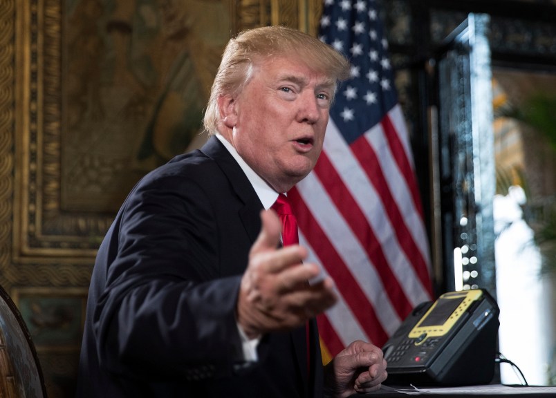 President Donald Trump turns to talk to the gathered media during a Christmas Eve video teleconference with members of the mIlitary at his Mar-a-Lago estate in Palm Beach, Fla., Sunday, Dec. 24, 2017. (AP Photo/Carolyn Kaster)