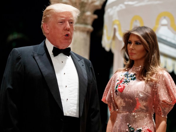 First lady Melania Trump looks on as President Donald Trump speaks with reporters after arriving for a New Year's Eve gala at his Mar-a-Lago resort, Sunday, Dec. 31, 2017, in Palm Beach, Fla. (AP Photo/Evan Vucci)