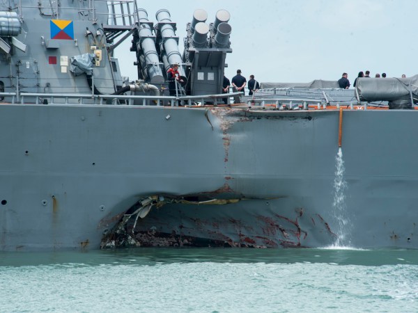 170821-N-OU129-022CHANGI NAVAL BASE, REPUBLIC OF SINGAPORE – Damage to the portside is visible as the Guided-missile destroyer USS John S. McCain (DDG 56) steers towards Changi Naval Base, Republic of Singapore, following a collision with the merchant vessel Alnic MC while underway east of the Straits of Malacca and Singapore on Aug. 21. Significant damage to the hull resulted in flooding to nearby compartments, including crew berthing, machinery, and communications rooms. Damage control efforts by the crew halted further flooding. The incident will be investigated. (U.S. Navy photo by Mass Communication Specialist 2nd Class Joshua Fulton/Released)
