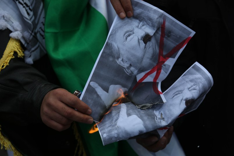 Palestinians burn posters depicting U.S. President Donald Trump and a U.S. flag and Israeli flag during a protest against Trump's decision to recognize Jerusalem as the capital of Israel, in Gaza City on January 15, 2018. (Photo by Majdi Fathi/NurPhoto)
