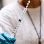 BETHESDA, MD - NOVEMBER 21: Nurse Floreliz Mendoza holds the syringe she has used to inject Andie Vaught, 25, with an experimental Zika vaccine as part of a clinical trial at the National Institute of Health Clinical Center in Bethesda, Maryland, November 21, 2016. This vaccine, one of about six or seven in different phases of clinical trial, is currently undergoing safety testing at three locations in the country. Instead of using dead or weakened virus to get the immune system to recognize the infection and fight it off, it uses a piece of DNA engineered to contain genes that code for proteins of the Zika virus. (Photo by Allison Shelley/For The Washington Post)