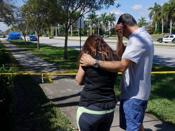 Azra, left, and Unser Khan of Parkland grieve outside of Marjory Stoneman Douglas High School in Parkland, Thursday, Feb. 15, 2018. The family's adult children are both graduates of the school. (Joe Cavaretta/Sun Sentinel/TNS)