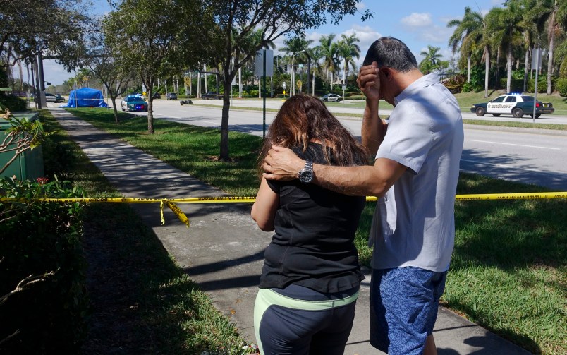 Azra, left, and Unser Khan of Parkland grieve outside of Marjory Stoneman Douglas High School in Parkland, Thursday, Feb. 15, 2018. The family's adult children are both graduates of the school. (Joe Cavaretta/Sun Sentinel/TNS)